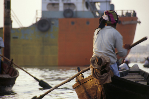 Boat in front of freighter on Dhaka River