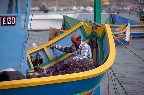 Fisherman mending his nets
